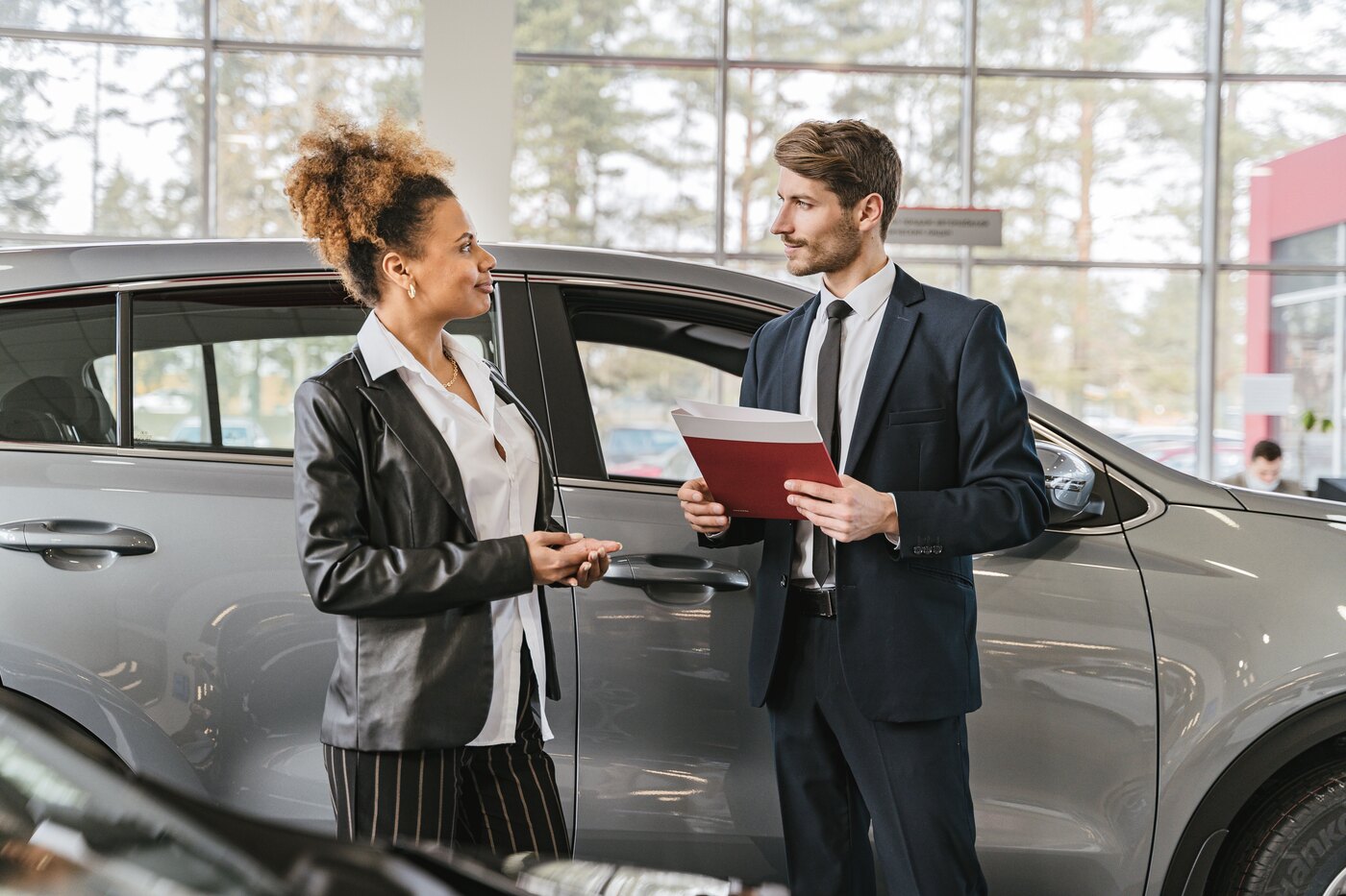 An F&I consultant reviewing finance paperwork with a customer at a dealership